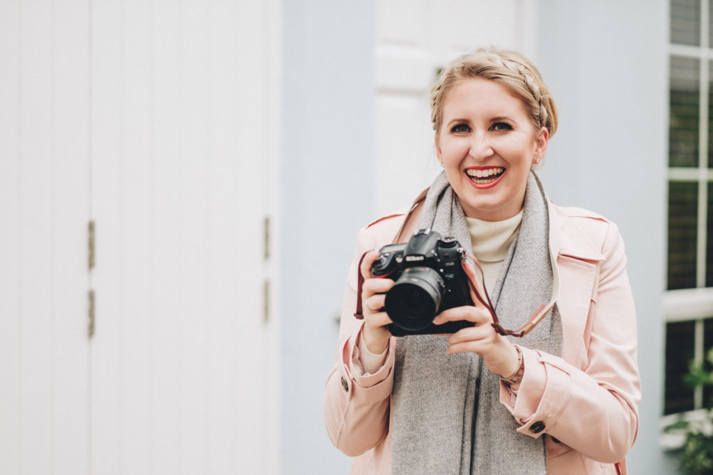 woman holding a camera during her personal brand photoshoot in london