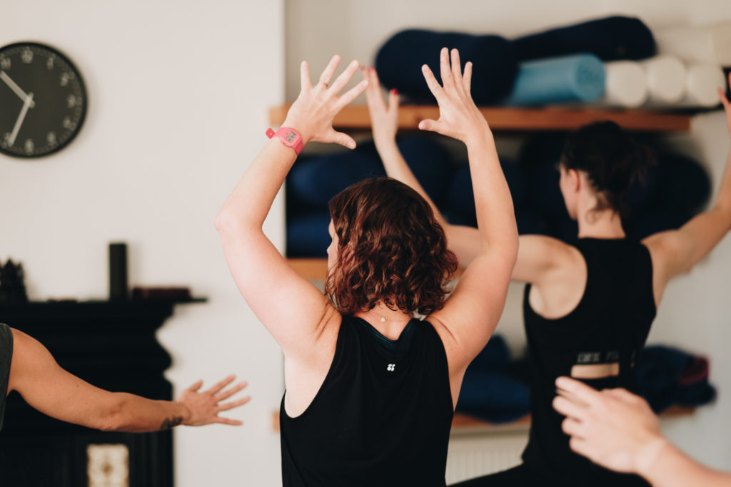 a yoga class with arms out wide